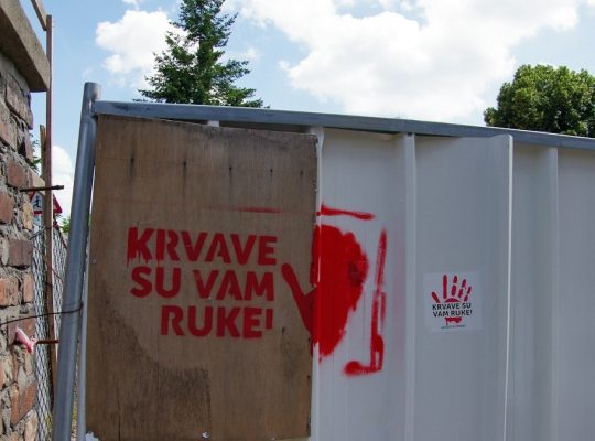 Red handprint and text on a fence