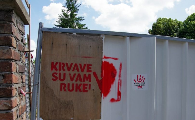 Red handprint and text on a fence